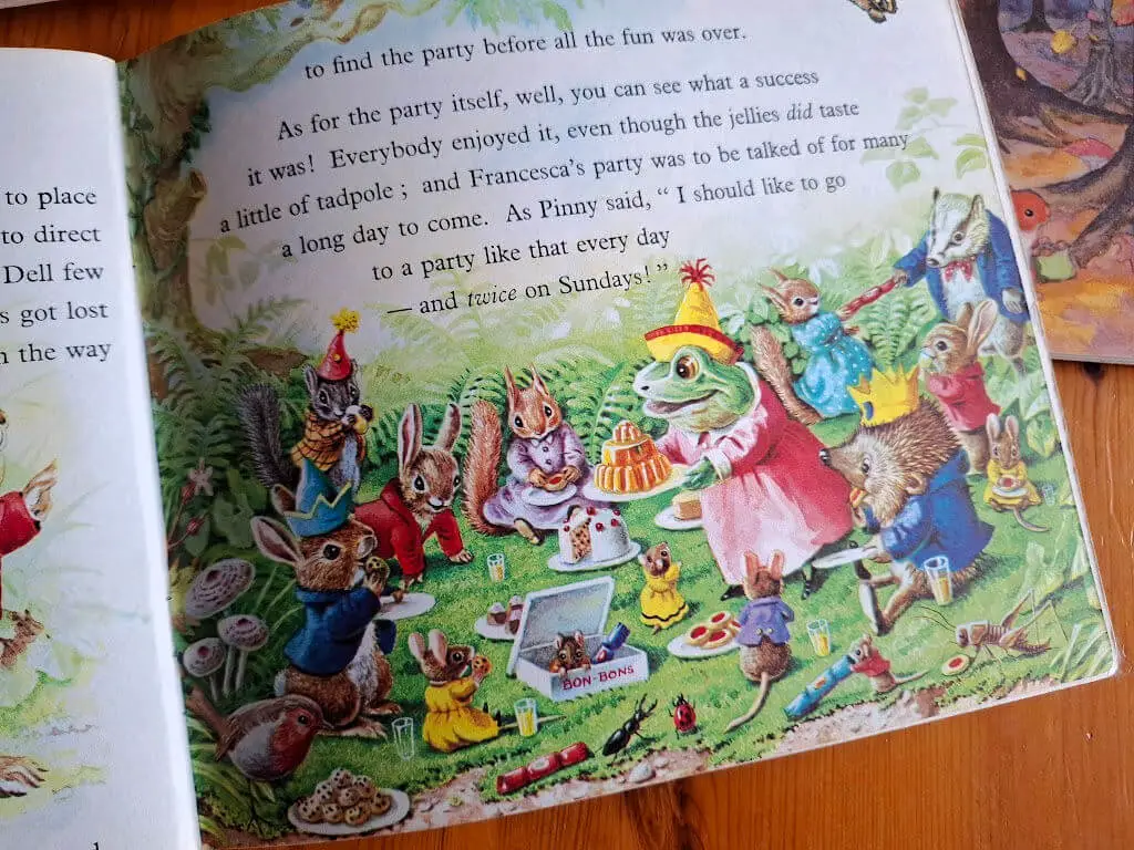 A story book page showing a frog in a pink dress wearing a party hat and carrying a large jelly on a plate.  Other animals are sitting around on the grass enjoying the party