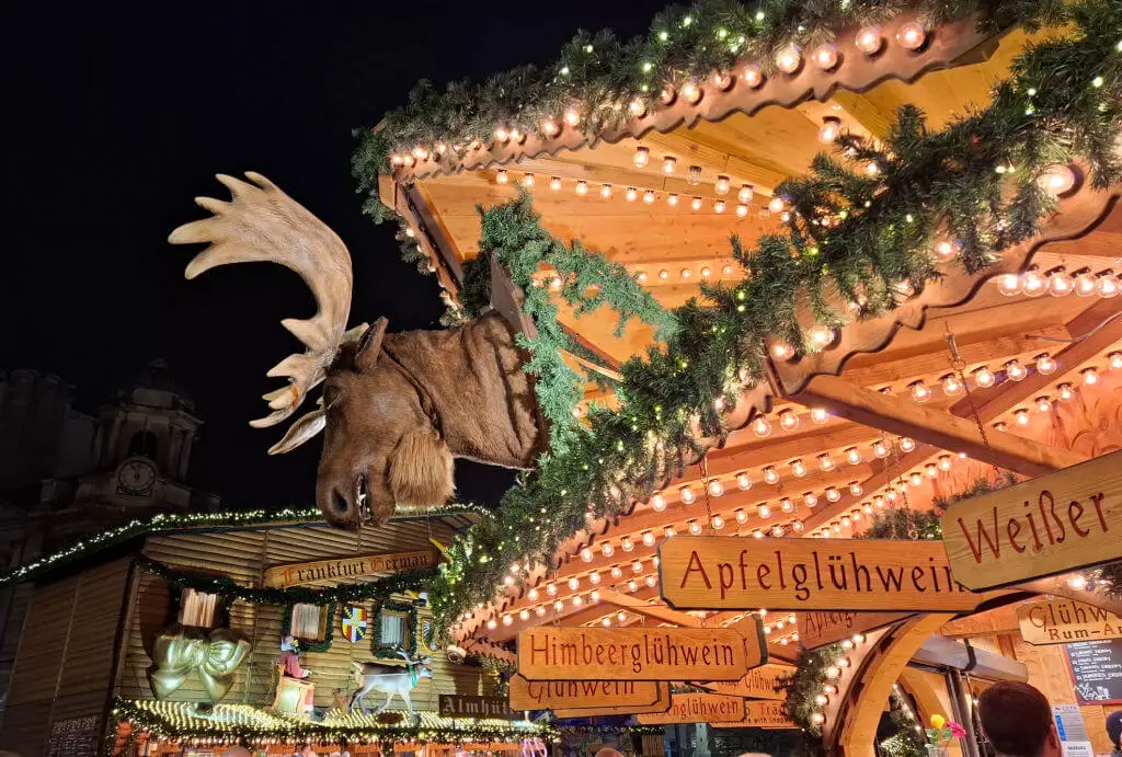 A moose head on a wooden Christmas market stall