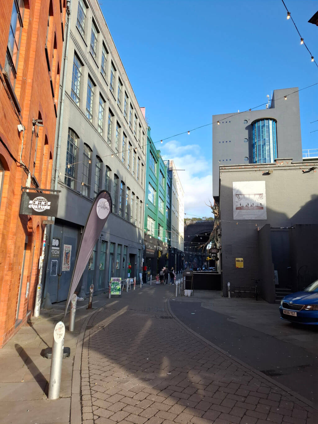 A narrow alleyway with shops painted in different colours
