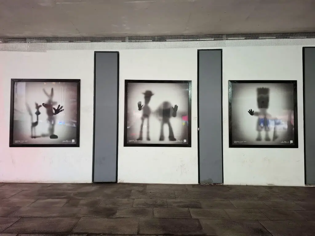 Three pictures of well-known cartoon characters silhouetted on an underpass wall