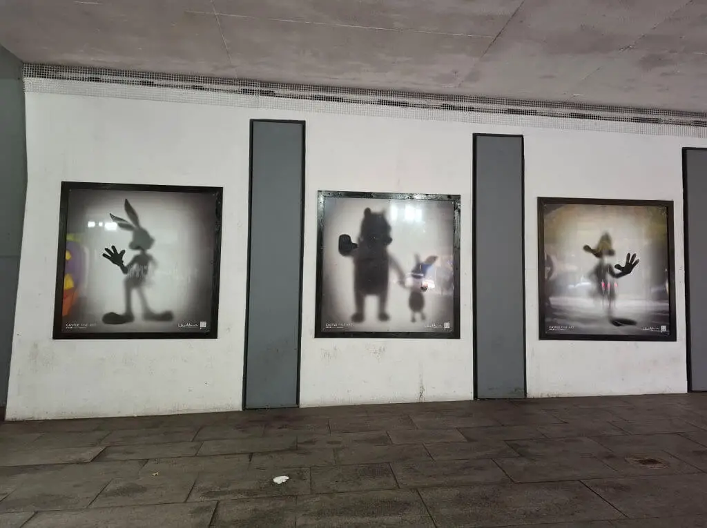 Three pictures of well-known cartoon characters silhouetted on an underpass wall