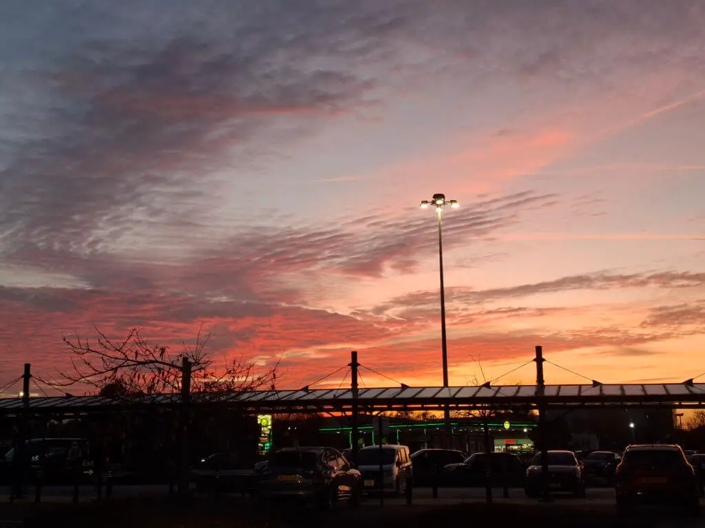 A view across a car park of a sunset