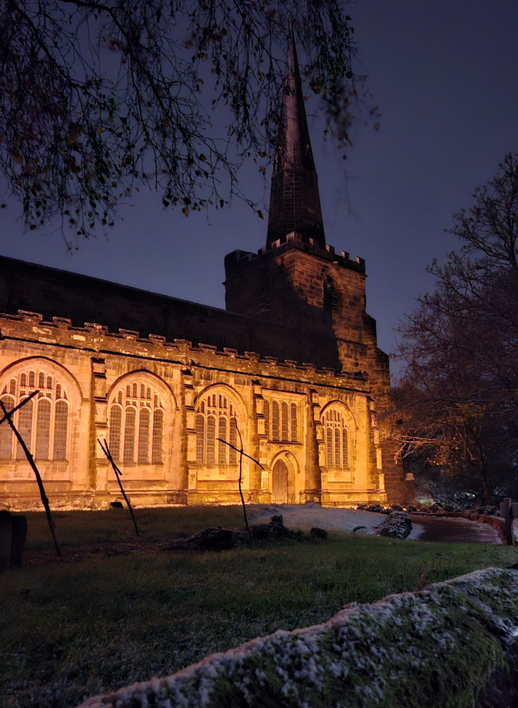 A closer view of a church at night, lit by floodlights