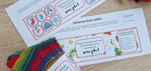 A striped multi-coloured pair of socks wrapped up with a decorated label. Another different label is also on the table to see