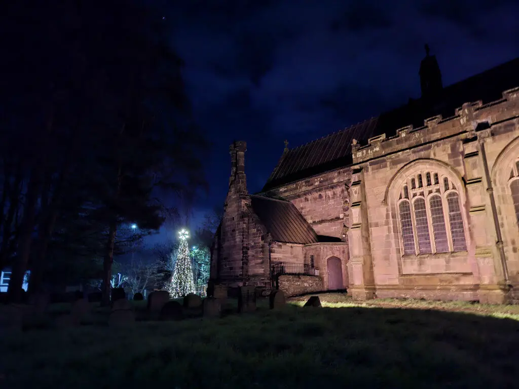 A closer view across the churchyard at Winwick church to the Christmas tree