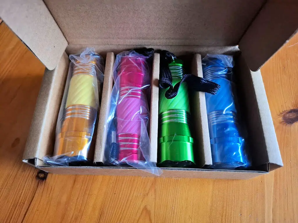 A cardboard box containing four coloured torches