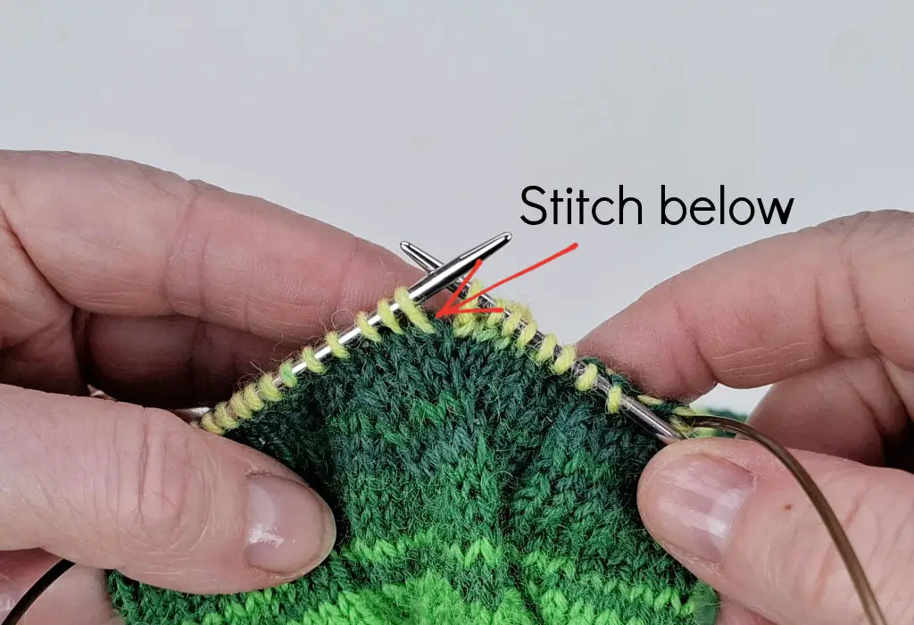 A close up of knitting on needles to explain an increase stitch