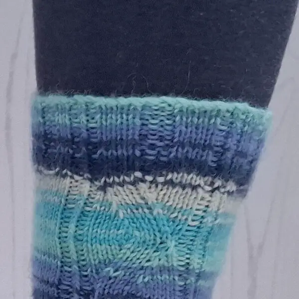 A close up of the cuff of a blue striped sock