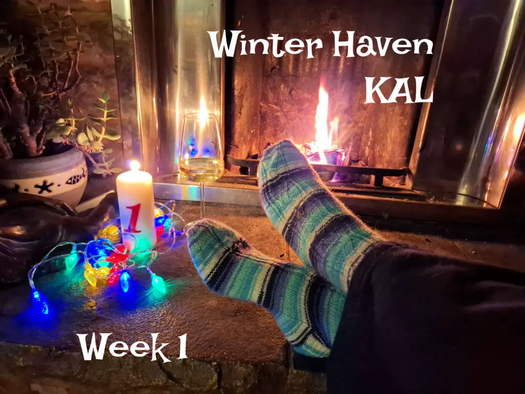 A pair of feet modelling blue and white striped socks on a stone hearth next to an open fire and a candle surrounded by fairy lights