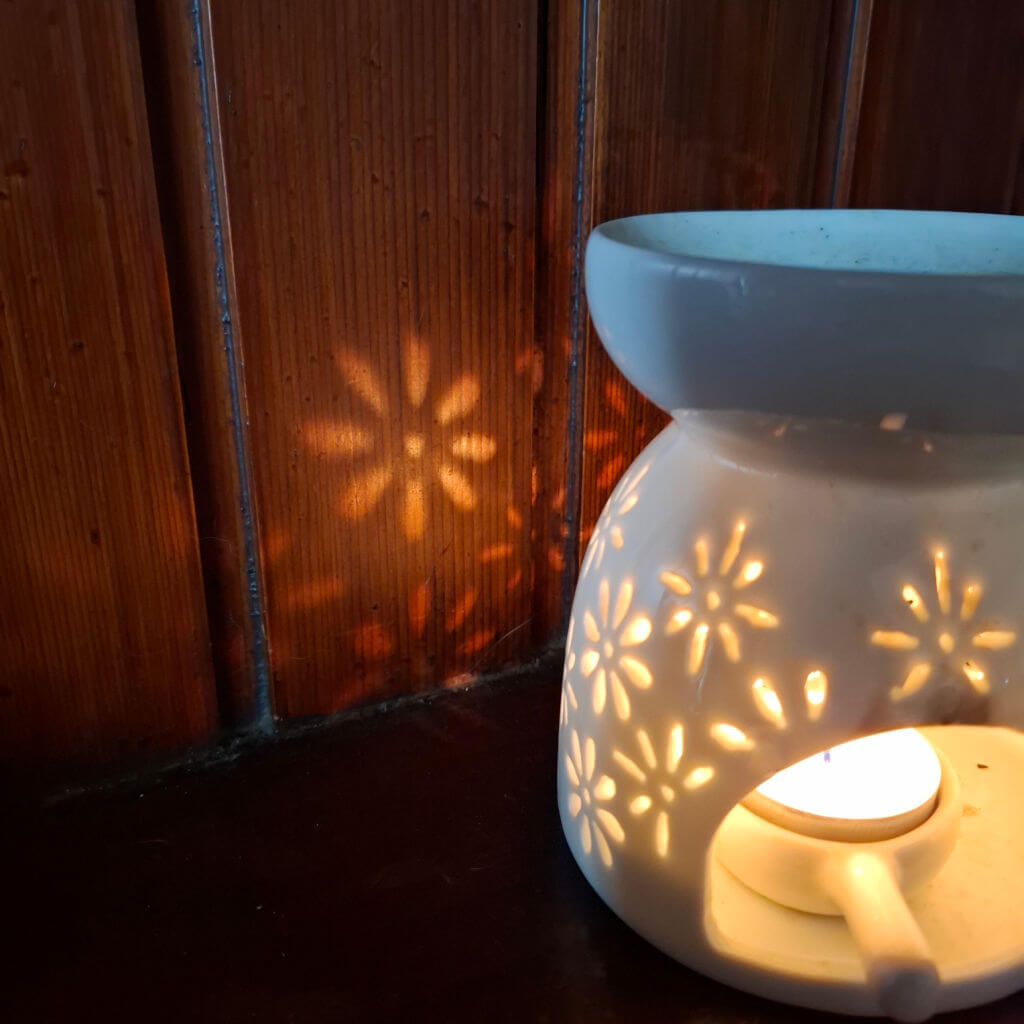 Light in the shape of flowers reflected from a candle onto a wooden wall