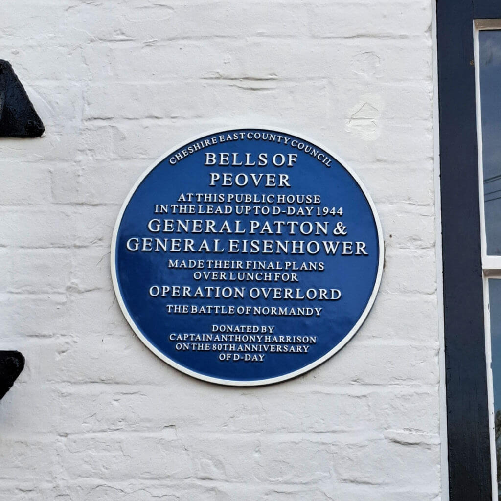 Blue plaque on a white wall, commemorating where generals planned Operation Overlord. Text mentions General Patton and General Eisenhower in 1944.