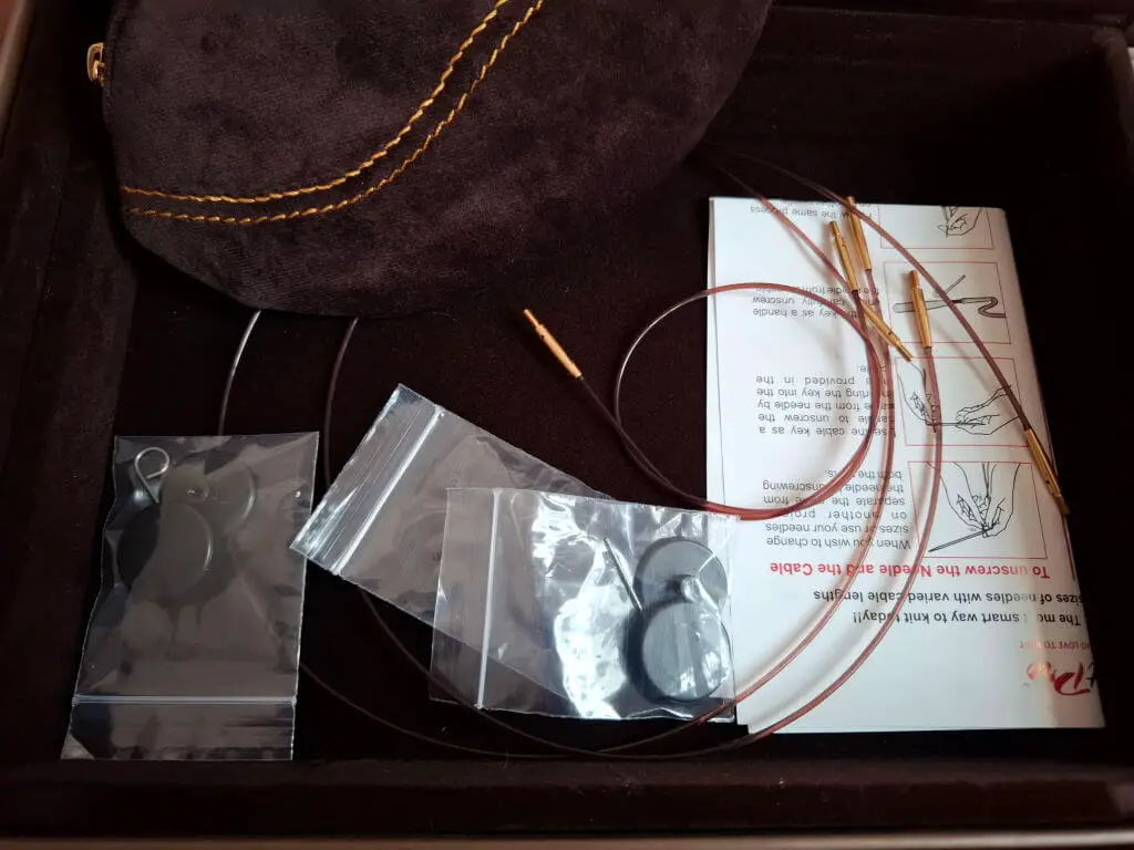 Knitting kit in a box with a fabric pouch, circular knitting needles, plastic zip bags, and a folded instruction sheet, conveying a crafting theme | Winwick Mum KnitPro Knit & Sip Set Review
