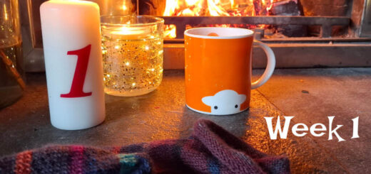 Cosy scene by a fireplace with an orange mug, a lit candle marked "1," a partly-knitted sock, and warm lighting. Text: "Winter Haven KAL, Week 1."