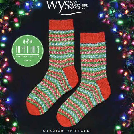 Festive knit socks with green, red, and white patterns are surrounded by colourful Christmas lights. Label reads "Fairy Lights Christmas Edition."