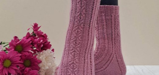 Pink twisted stitch knit socks modelled on feet beside a bouquet of magenta and white chrysanthemum flowers, creating a cosy, handcrafted mood. Winwick Mum | September Socks